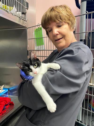 Volunteer Heather Mahood holding a black and white cat