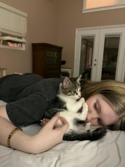 Lily snuggling on a bed with a kitten