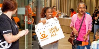 Woman happily walking out with a newly adopted cat in a cardboard carrier