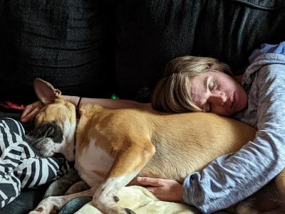 Person sleeping snuggled with Homer the dog