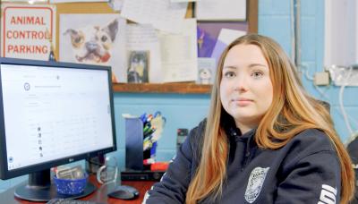 Person from Harrison County Animal Control beside a computer screen