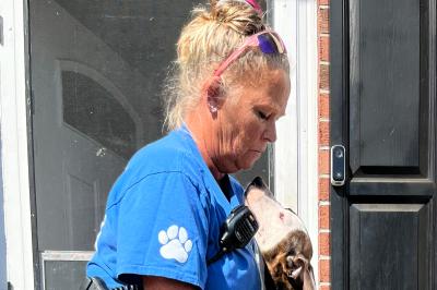 Missy in her animal control uniform with a dog