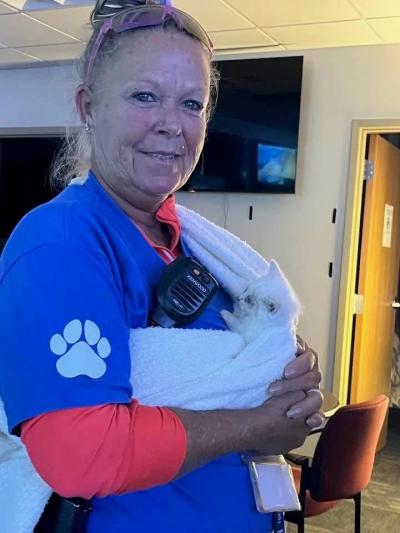 Melissa “Missy” Kidwell holding a white kitten in a sling