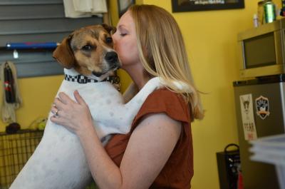 Person kissing a large dog whose front paws are up on her shoulders