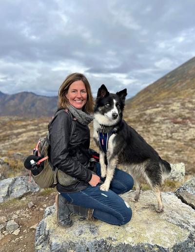 Rachael Rodgers with a dog outside on a mountain