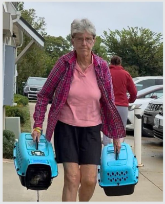 Volunteer Sharon carrying two small carriers