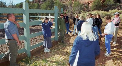 Best Friends co-founder Faith Maloney teaching a workshop outside next to a horse enclosure