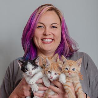 Courtney Bean holding four kittens