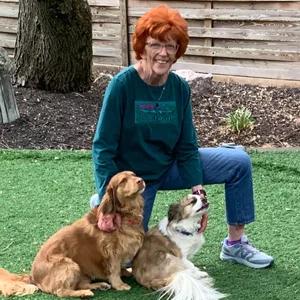Peggy Hall outside with two small dogs