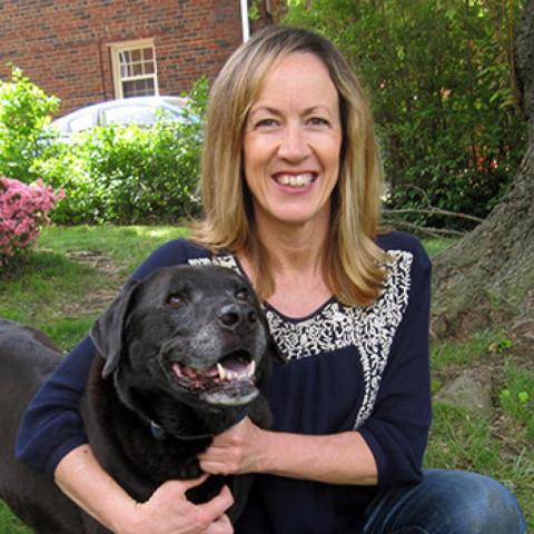 Greta Palmer in yard with large black dog