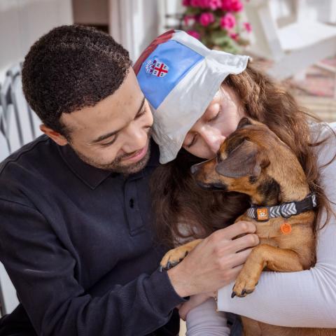 Man and woman cuddling with foster dog