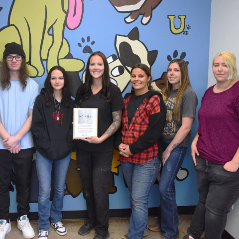 Group of people holding a no-kill award plaque