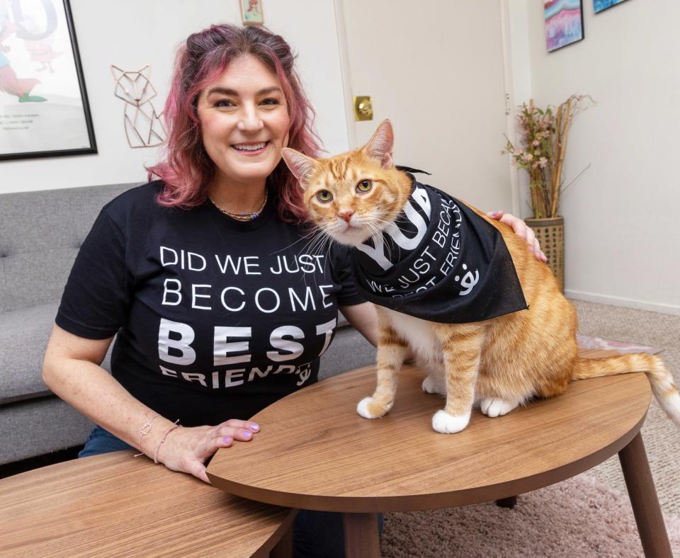 Smiling person wearing a Best Friends T-shirt that coincides with a bandanna a cat is wearing