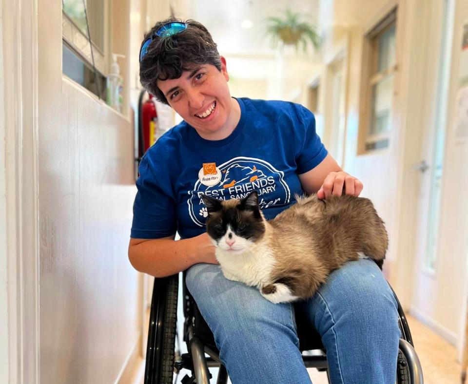 Best Friends volunteer in a wheelchair with a cat in her lap