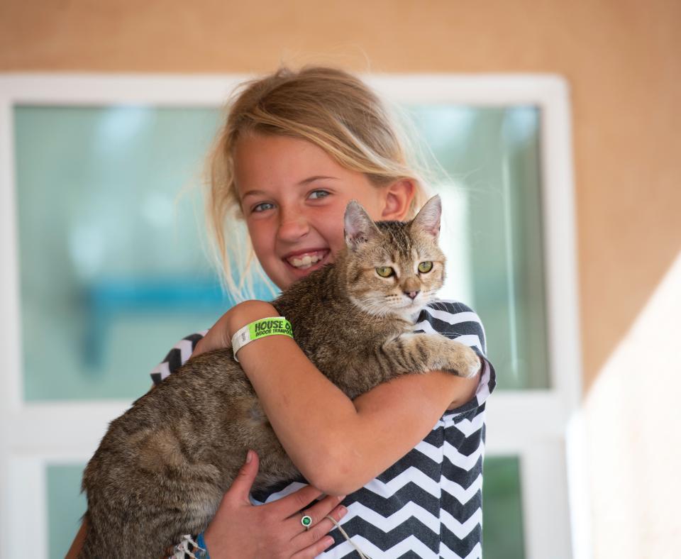 Young volunteer smiling and holding a cat