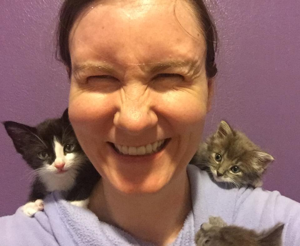 Lizel Allen laughing with a kitten on each of her shoulders