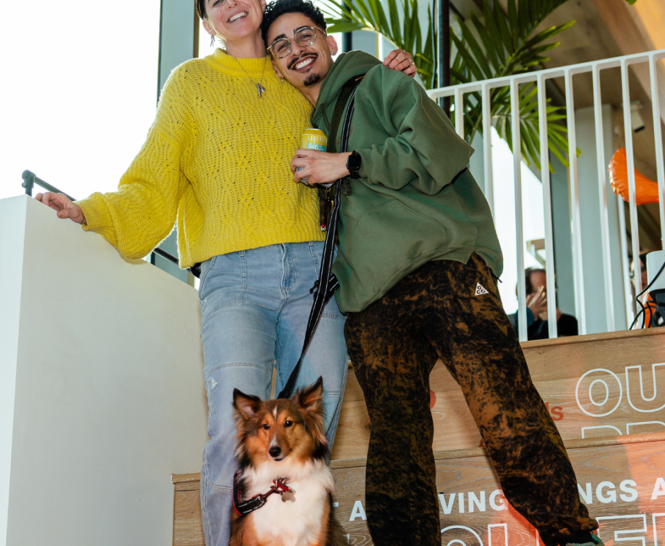 A young couple and cute dog standing together.