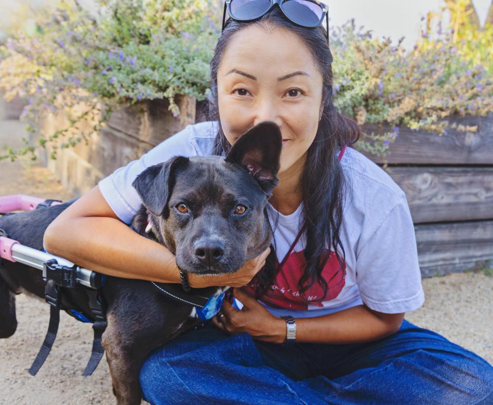 Ranko Fukuda hugging Kody the dog, who is in her wheelchair