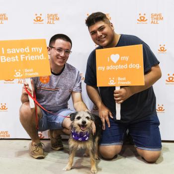 New adopters smiling with their dog at pet adoption event