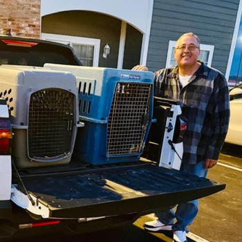 Jim Hess beside some carriers in the back of a pickup truck