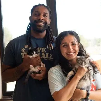 Two smiling people holding kittens at Best Friends Animal Sanctuary