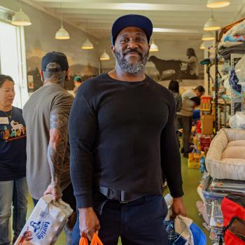 Man smiling while donating pet supplies.