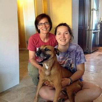 Layla the dog in her new home seated with people