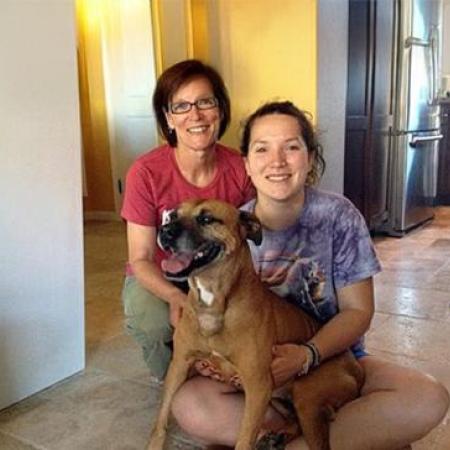 Layla the dog in her new home seated with people