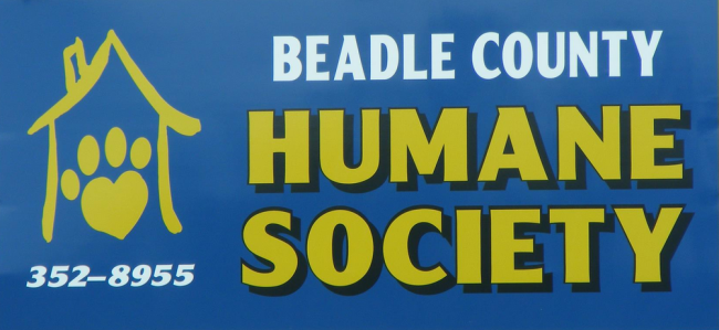 Beadle County Humane Society (Huron, South Dakota) logo blue background yellow drawn house with roof chimney and two sides yellow paw print inside white yellow with black outline lettering