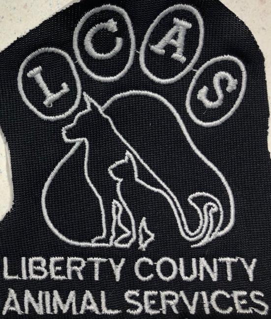 Liberty County Animal Services (Hinesville, Georgia) logo black patch with grey stitching paw print dog and cat silhouette stitched inside paw pad letters inside toes grey text below