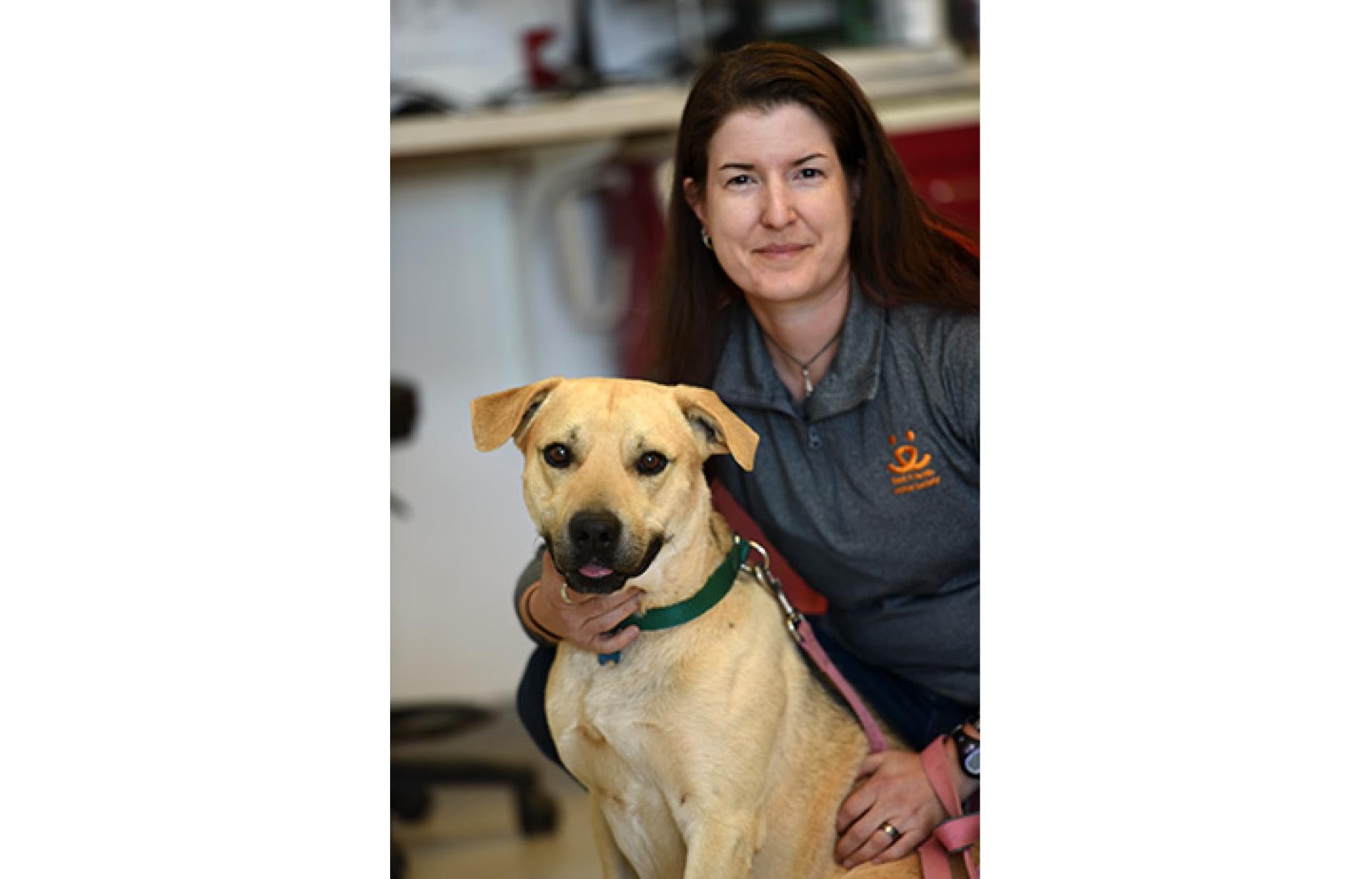 Dr. Erin Katribe, Medical Director with a yellow Lab dog