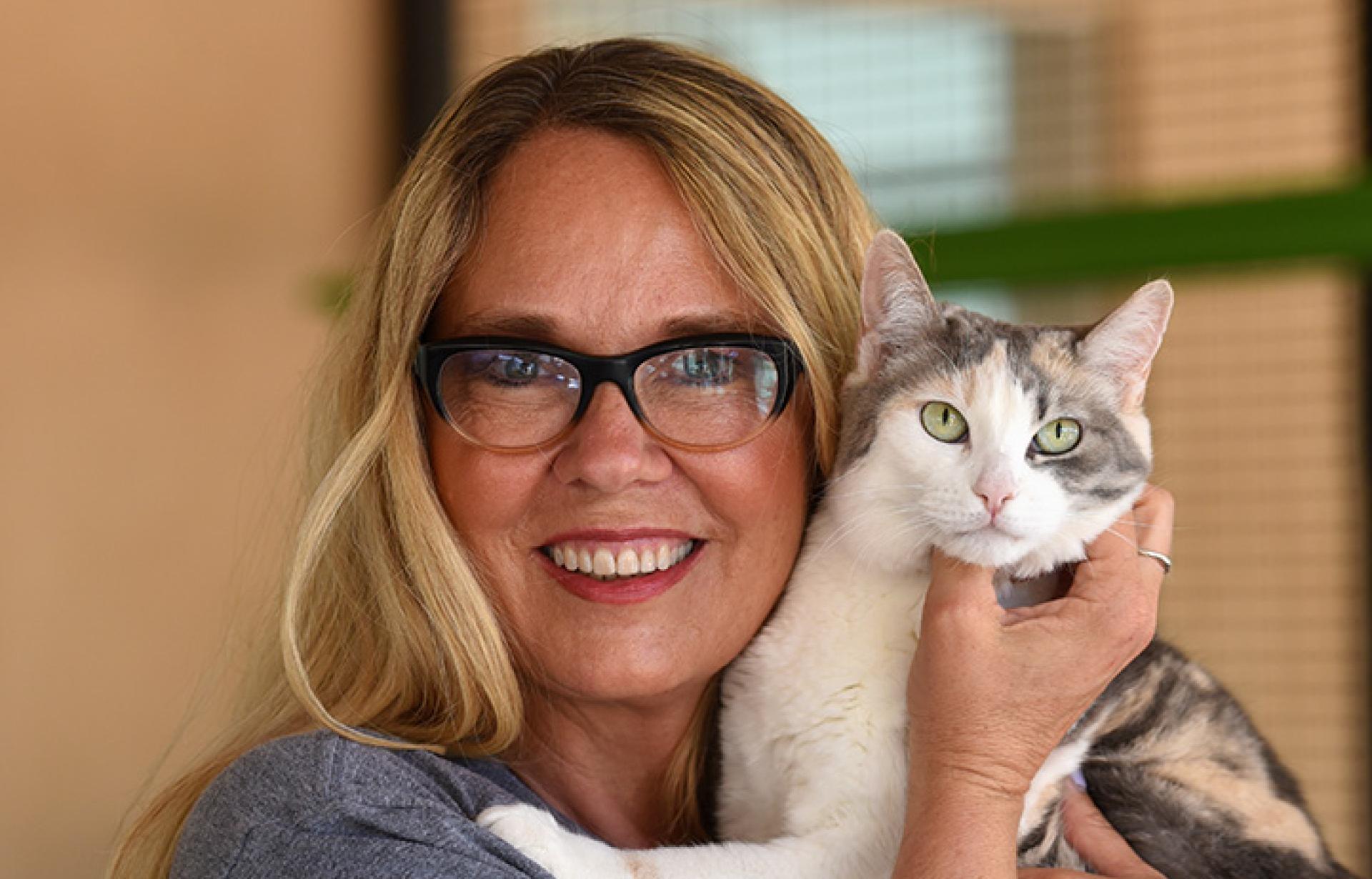 Julie Castle holding Sweetness, a dilute calico cat
