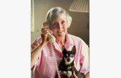 Best Friends co-founder Charity Rennie on a phone with a small dog in her lap