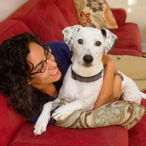 Woman hugging dog on couch