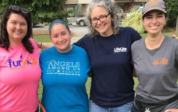 Four ladies standing together with landscape behind