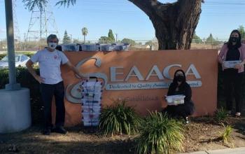 People with kitten kits standing in front of shelter sign