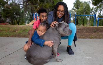 family hugging their dog