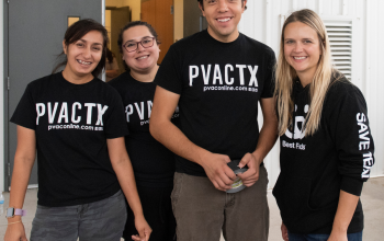 Three women and one man posting for a group photo in shirts for PVACTX
