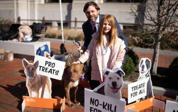 Father and daughter standing with their dog and holding signs advocating for no-kill 