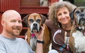 A couple with two boxer dogs