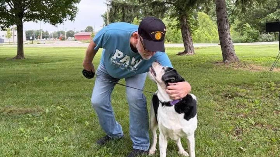Anastasia the dog and her adopter, who is giving her a hug