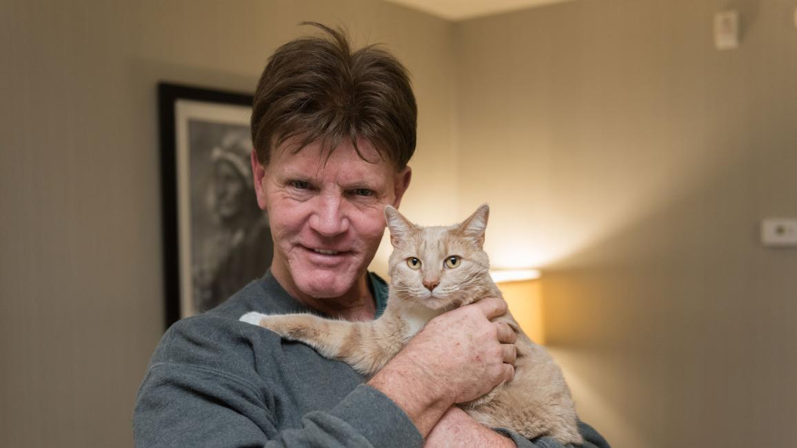 Volunteer Bill Coaker holding Rio the cat