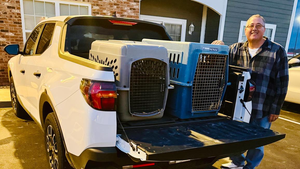 Jim Hess beside some carriers in the back of a pickup truck