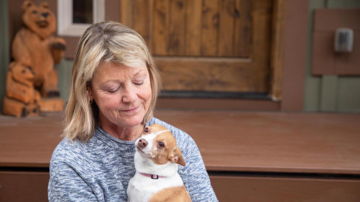 Bonita Vanderkooi holding a small brown and white dog in her arms