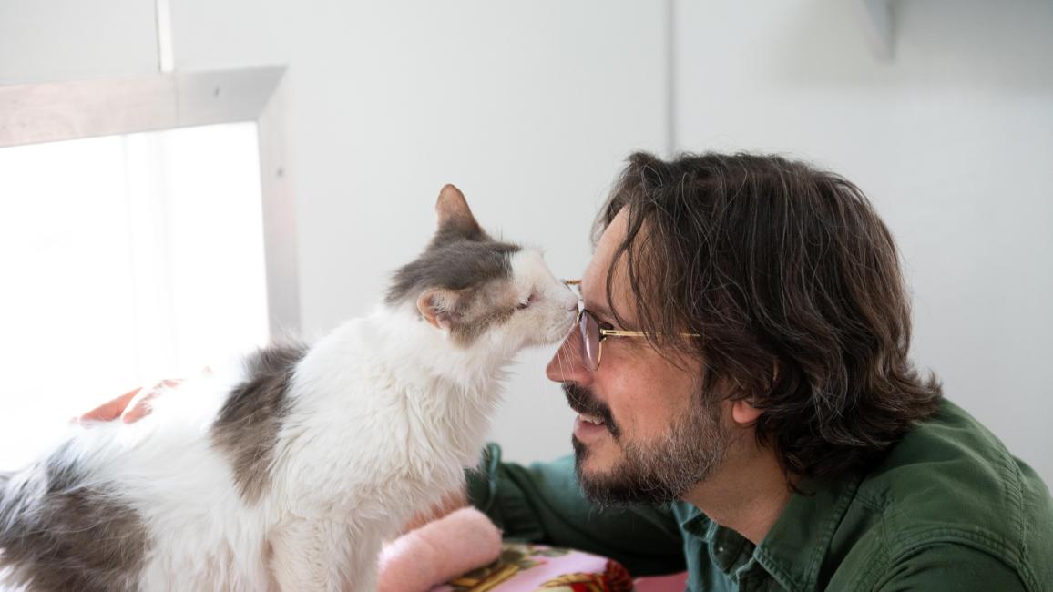 Bubba the cat sniffing Jesse the caregiver's face