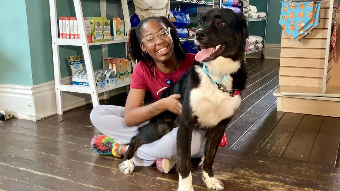 K’Terra sitting on the ground with a dog