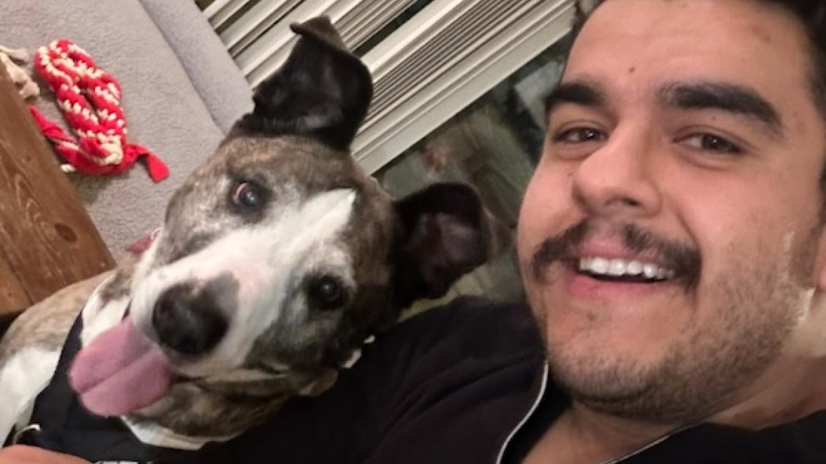 Selfie of Victor with Dakota the dog whose tongue is out