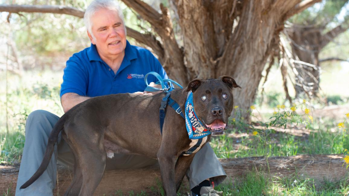 Dan with Moogan the dog outside under a tree