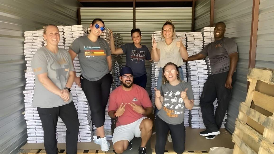 People in an area with pallets of pet food