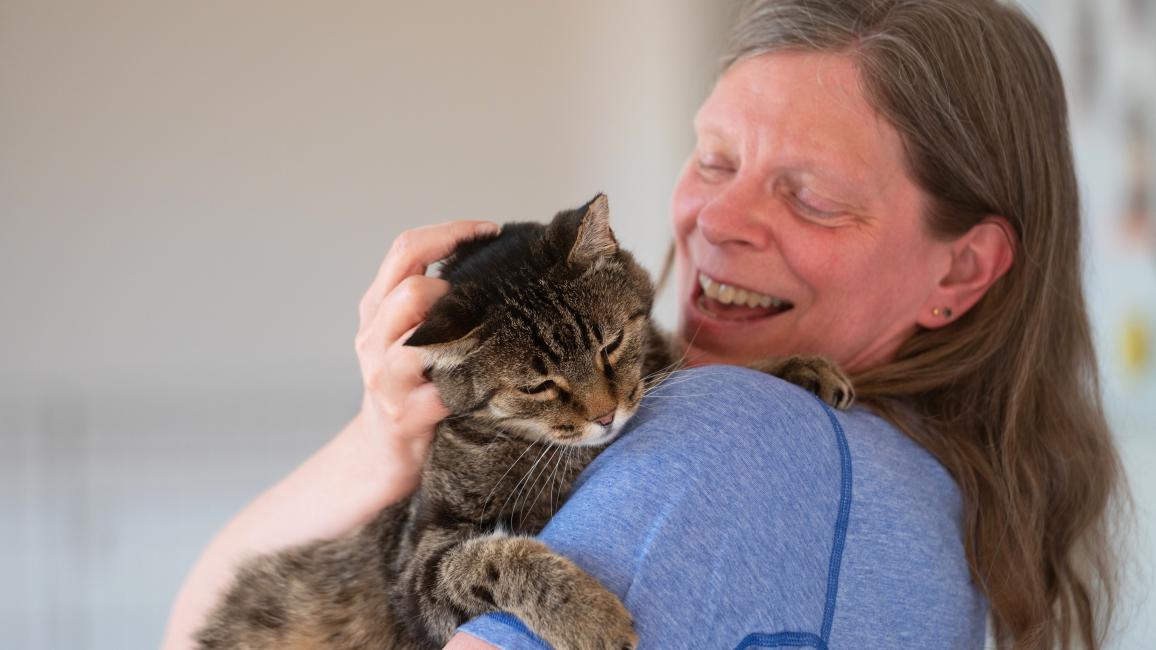 Leanne Parker smiling and holding Stannis the cat on her shoulder
